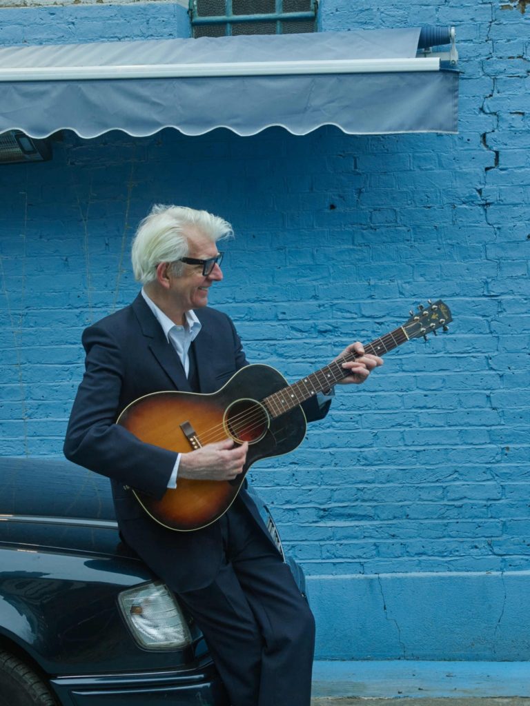 Nick Lowe with guitar, 2024