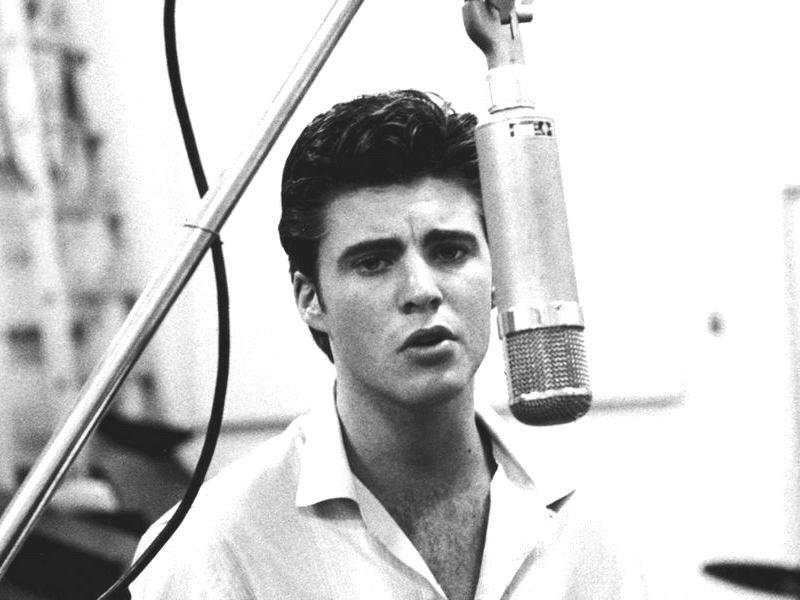 Ricky Nelson sings into a microphone in the studio, records a song 