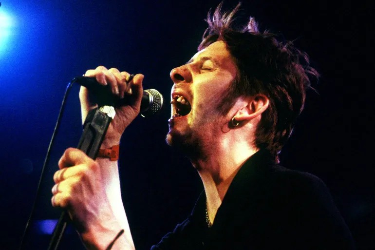 Shane MacGowan sings on stage, 1990