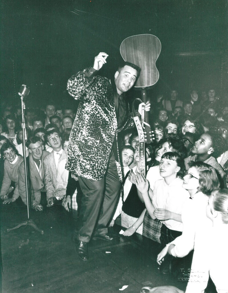 Big Bopper on stage with a guitar in a leopard jacket