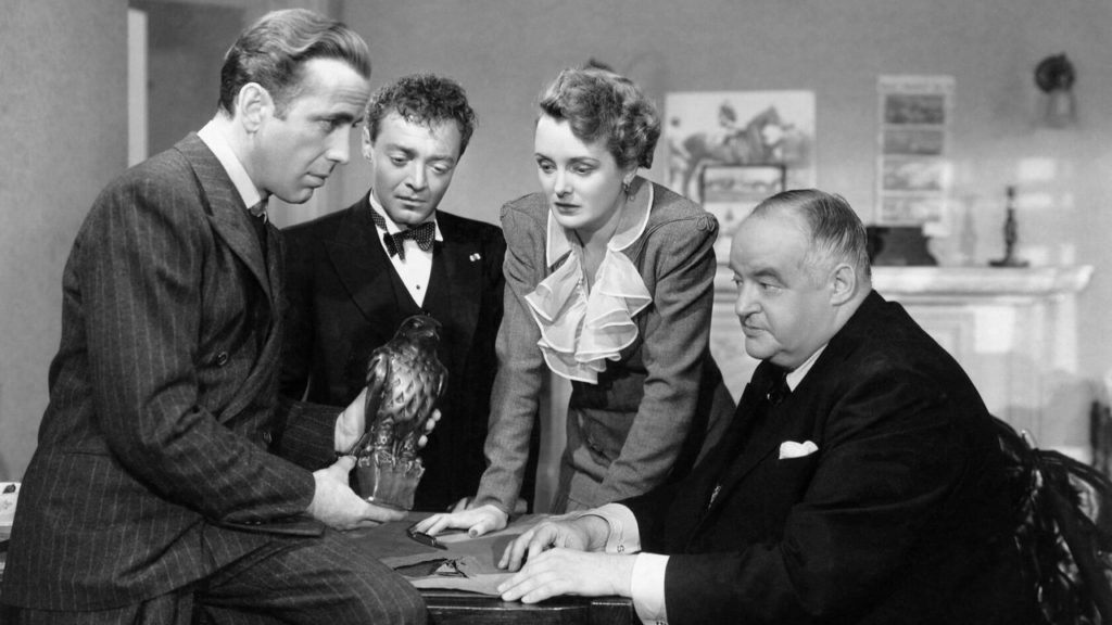 a shot from the movie Maltese Falcon, Sam Spade holding a statuette