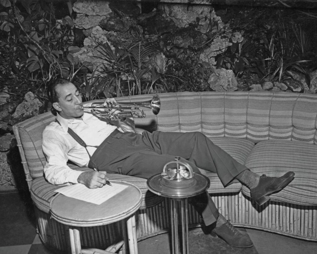 Louis Prima composes music playing the trumpet, 1950