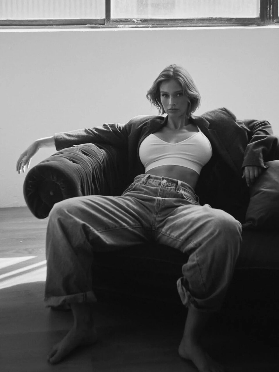 Naila van Kommer, in jeans and a tight white tank top